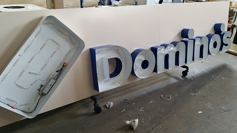 A Domino's channel letter sign in progress. The face hasn't been added yet, so the LEDs are exposed.
